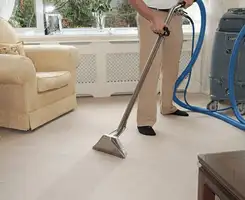 Carpet cleaning professional removing dirt and stains with a hot-water extraction tool in a home, Fort Lauderdale, FL.